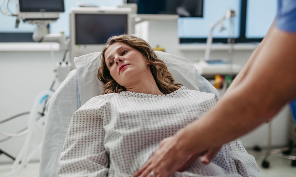 Doctor evaluating a patient with abdominal pain during a walk-in clinic visit in Sugar Land