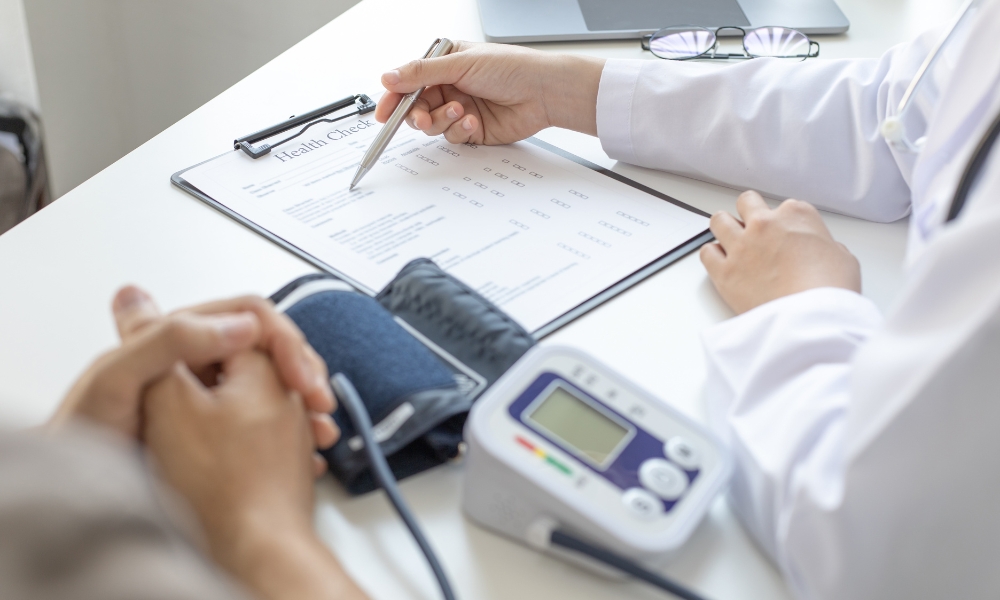 Doctor checking a patient's blood pressure during a routine primary care exam in Sugar Land, TX