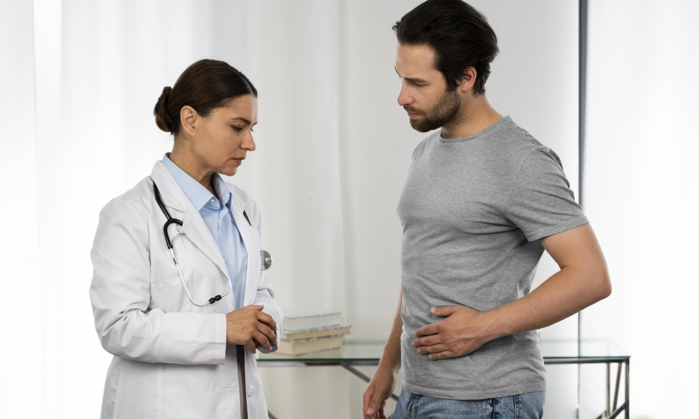 Primary care provider explaining the possible causes of abdominal pain and treatment options to a patient