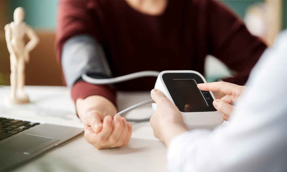 Healthcare provider checking a patient's blood pressure during a routine primary care examination in Sugar Land
